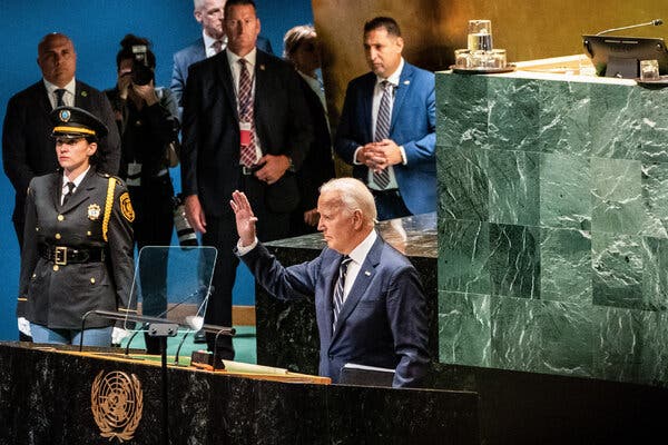 Pán Biden stojí za veľkým rečníckym pultom a máva publiku, ktoré nie je v zábere.