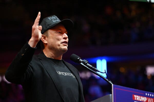 Elon Musk gestikuluje pri rečníckom pulte.